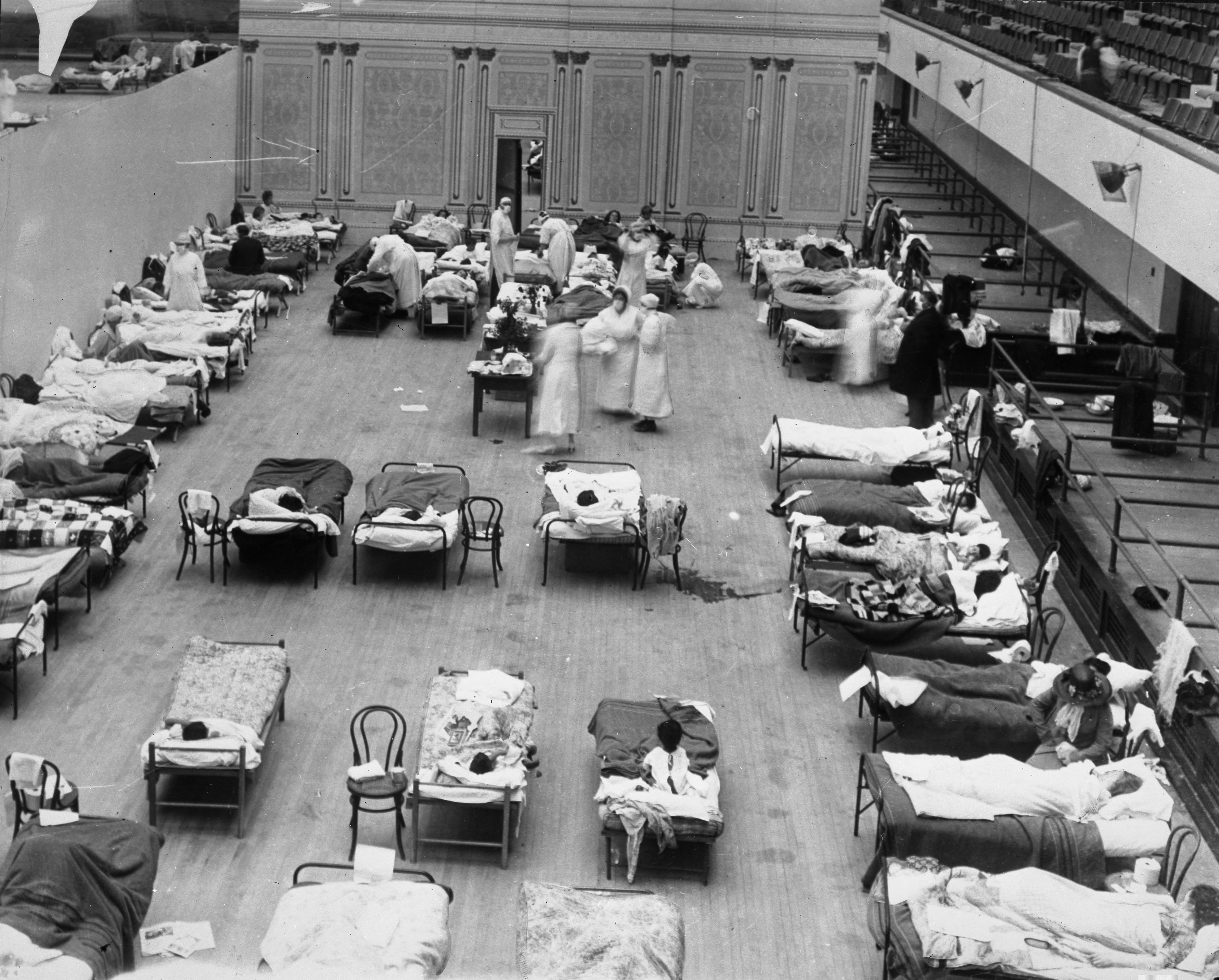 Enfermeras voluntarias de la Cruz Roja estadounidense atendiendo a los enfermos de gripe en la pandemia de 1918. El Auditorio Municipal de Oakland, California, habilitado como hospital provisional.